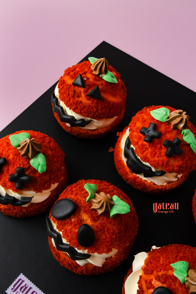 Pumpkin choux pastry decorated with chocolate faces and green leaves from Gateau Gourmet Cafe