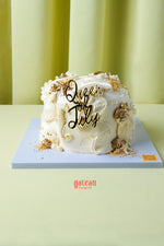 Queen of July birthday cake from Gateau Gourmet Cafe with white frosting and decorative gold accents