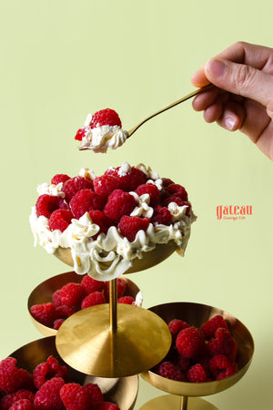 Decadent raspberries dessert cup topped with whipped cream and fresh raspberries from Gateau Gourmet Cafe