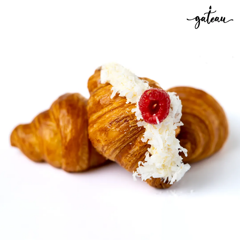 Gateau Gourmet Cafe raspberry coconut croissant topped with white coconut flakes and a fresh raspberry