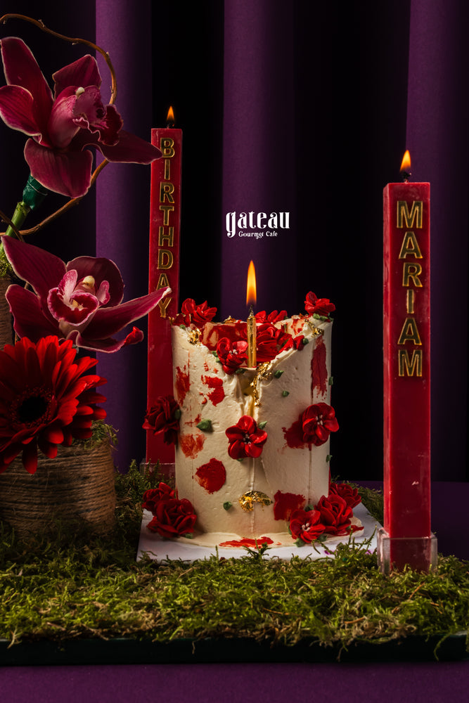 Red floral garden cake with red flowers and gold accents by Gateau Gourmet Cafe with personalized red candles