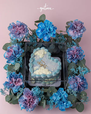 Gateau Gourmet Cafe romantic floral cake arrangement with blue and purple flowers surrounding a heart-shaped cake
