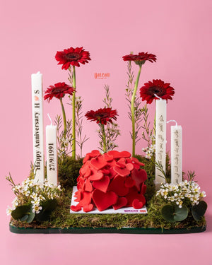 romantic heart cake arrangement by Gateau Gourmet Cafe with red heart decorations and candles on a floral base