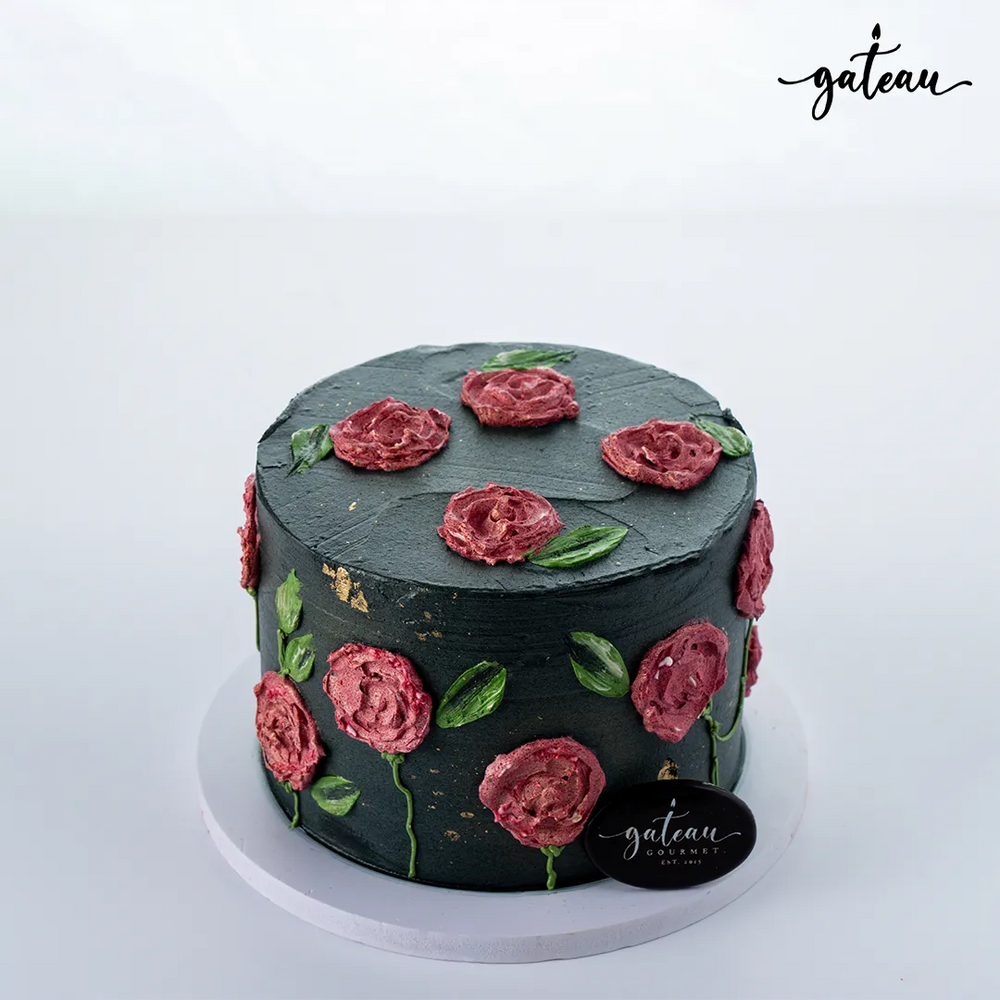 Elegant black rose-engrave cake adorned with pink icing roses and green leaves from Gateau Gourmet Cafe
