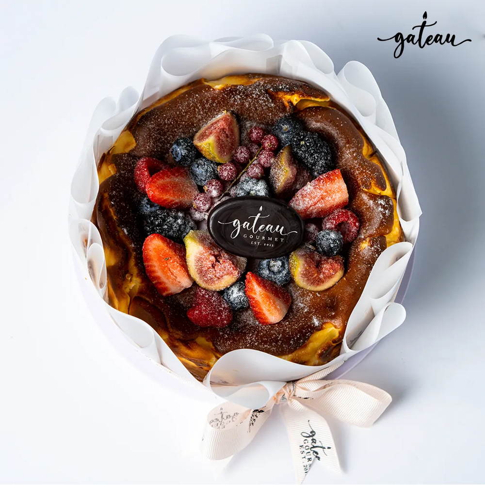 Gateau Gourmet Cafe San Sebastian cheesecake topped with fresh strawberries, figs, blueberries, and raspberries