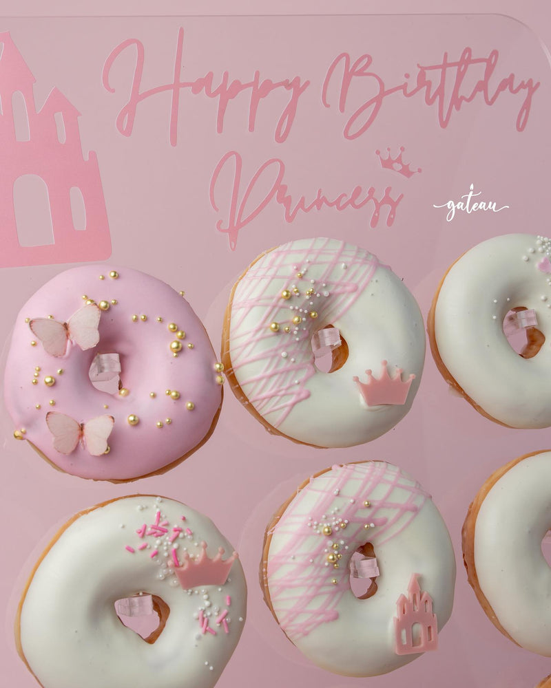 Special occasion donut treats from Gateau Gourmet Cafe decorated with pink and white icing, sprinkles, and princess-themed toppings
