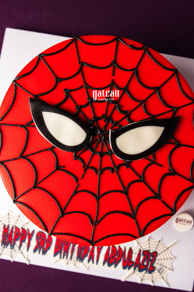 Spiderman theme cake for kids with red frosting and black web design from Gateau Gourmet Cafe