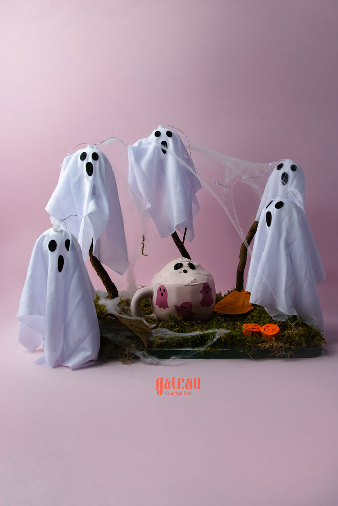 Spooky cake in a cup decorated with ghost figures and autumn leaves for Halloween celebrations