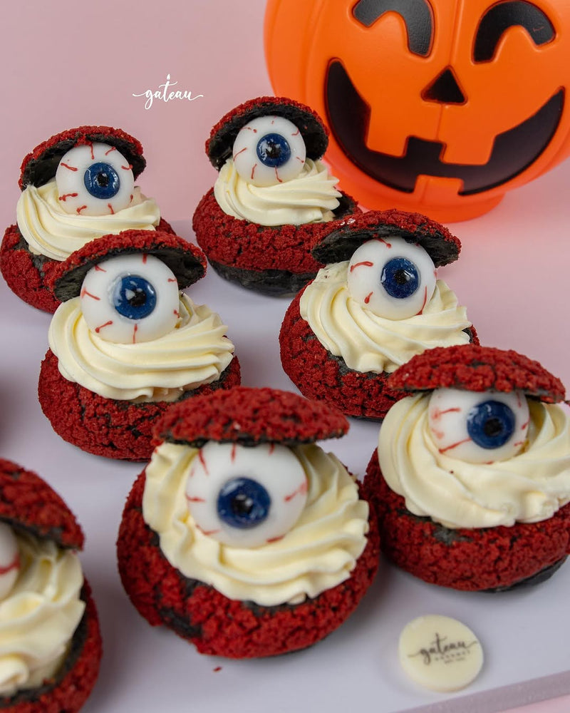 Gateau Gourmet Cafe spooky choux desserts with red shells, cream filling, and edible eyeball decorations for Halloween