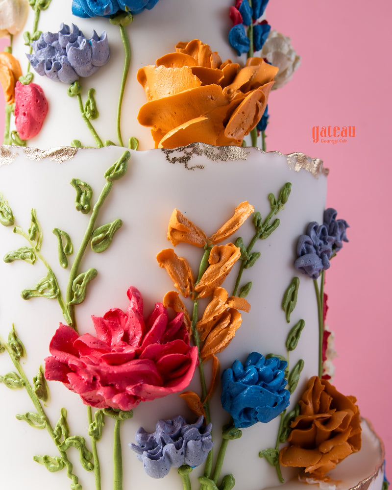 Gateau Gourmet Cafe cake with colorful spring flowers cake design featuring intricate floral icing decorations