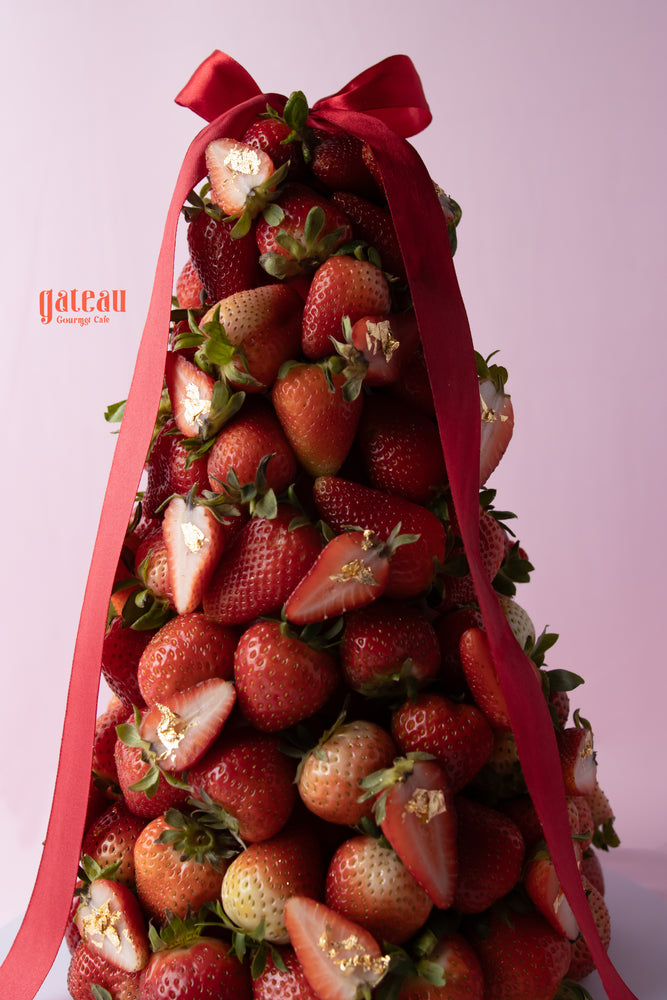Gateau Gourmet Cafe Strawberry and Cherry Dessert Tower topped with a red ribbon and fresh strawberries