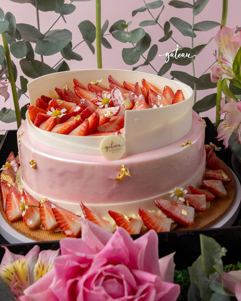 Elegant strawberry mousse cake arrangement decorated with fresh strawberries and golden accents