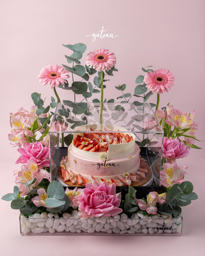 Elegant strawberry mousse cake arrangement decorated with flowers and greenery for special occasions