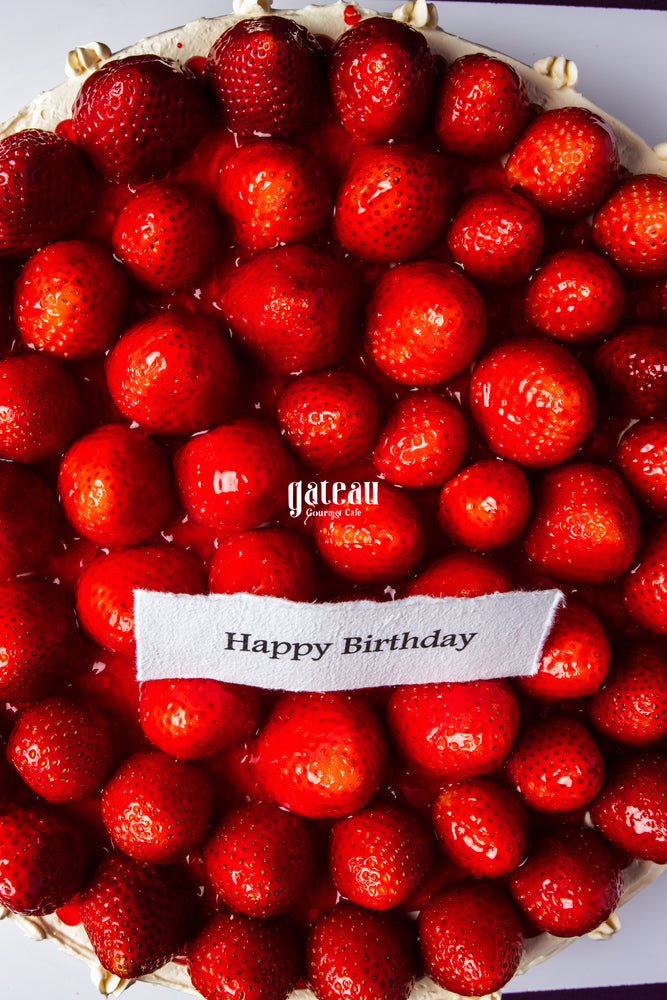 Gateau Gourmet Cafe strawberry sponge cake for celebration topped with fresh whole strawberries and Happy Birthday message