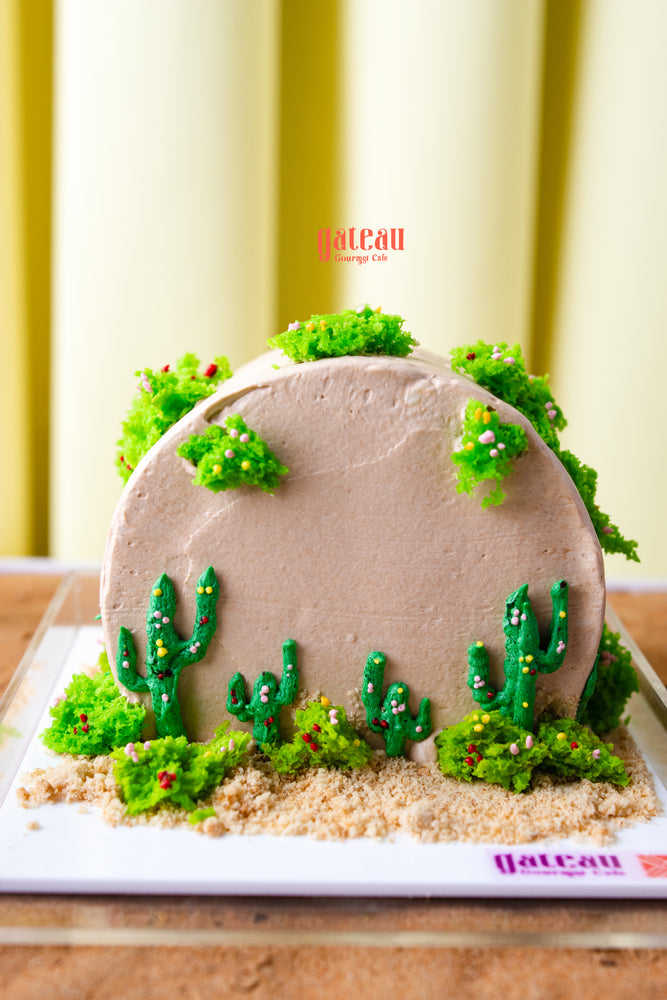 Gateau Gourmet Cafe summer cactus cake with green cactus decorations and sandy base