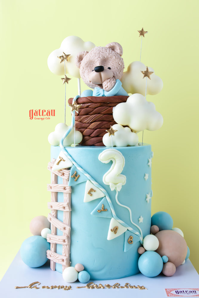 Whimsical teddy bear birthday cake with clouds and stars, perfect for celebrating a child's special day