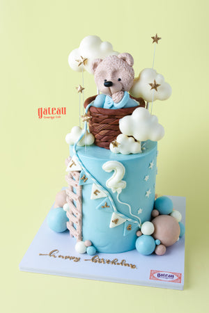 A cute teddy bear birthday cake with clouds, stars, and pastel decorations from Gateau Gourmet Cafe