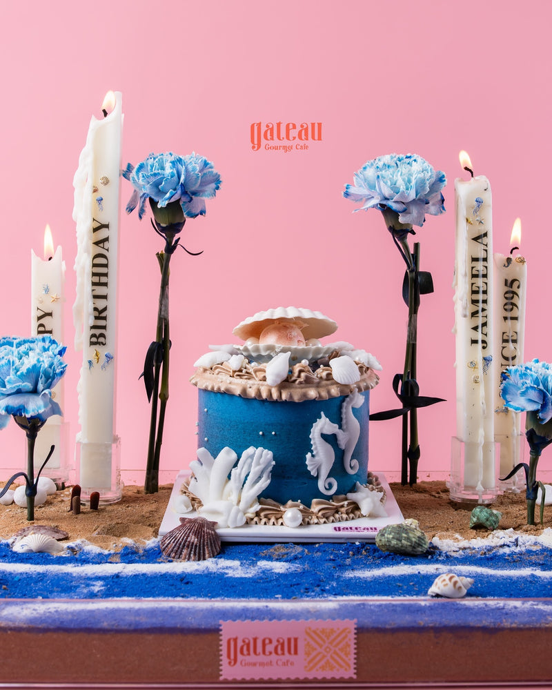Under the sea cake arrangement by Gateau Gourmet Cafe featuring blue ocean theme with seashells and seahorses