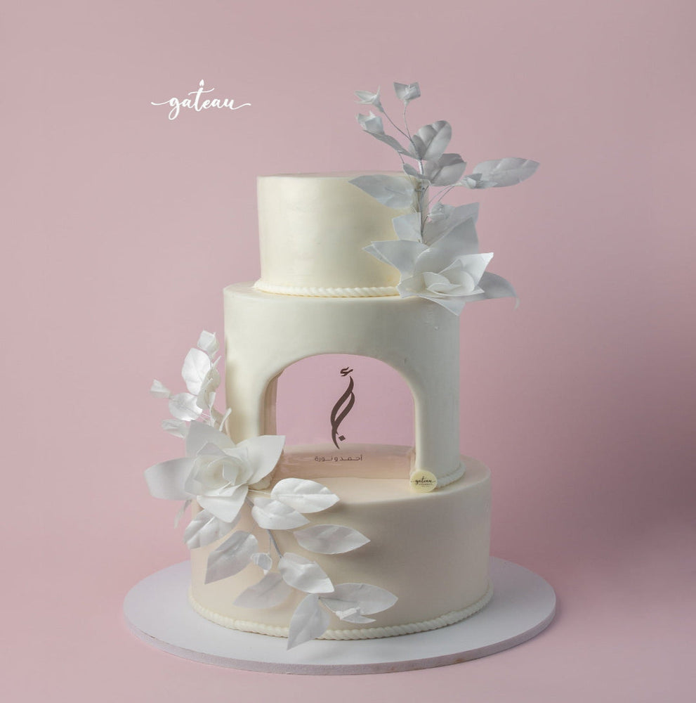 Gateau Gourmet Cafe undyed white wedding cake with three tiers and delicate white floral decorations