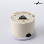 Minimalist white birthday cake with elegant black and gold decoration showcasing unique birthday cake designs by Gateau Gourmet Cafe