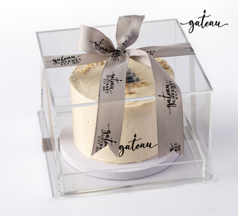 Gateau Gourmet Cafe elegant birthday cake in clear box with ribbon showcasing unique birthday cake designs