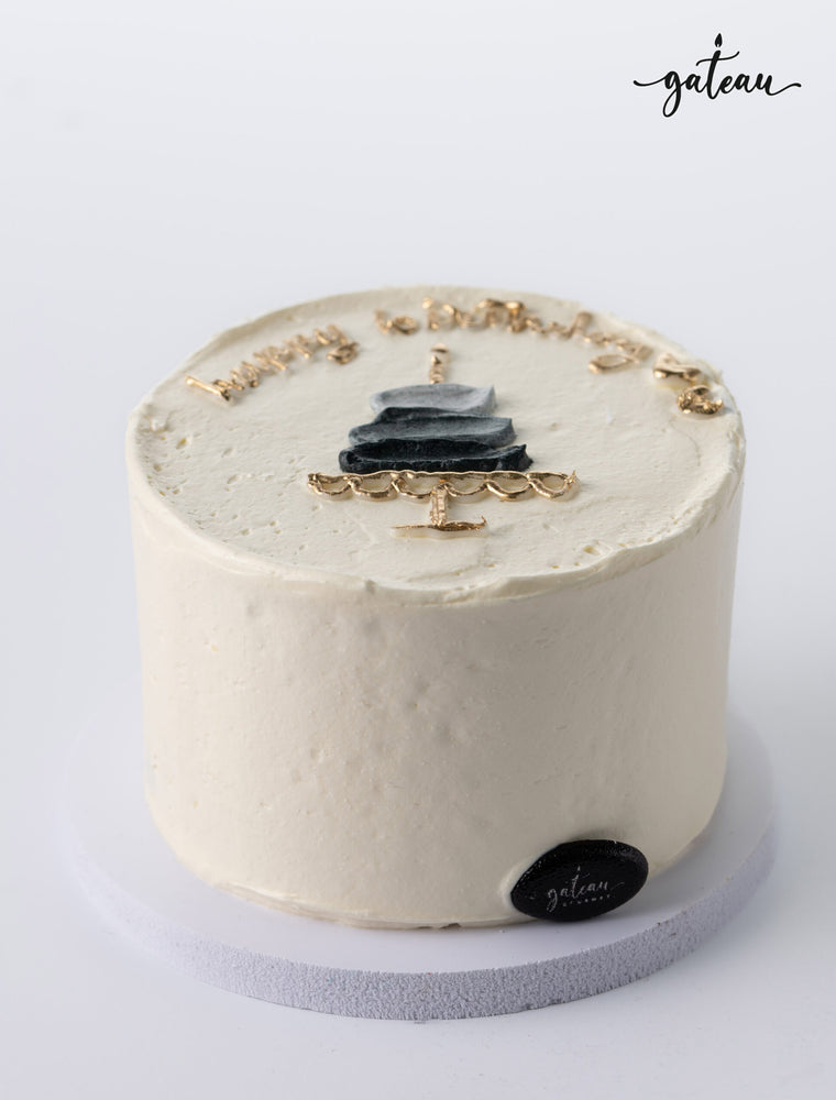 Simple white birthday cake with black and gold decoration showcasing unique birthday cake designs by Gateau Gourmet Cafe