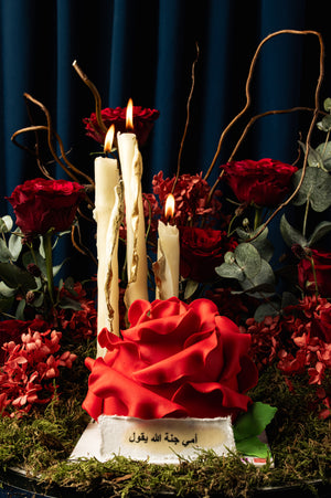 Unique Mother's Day floral cake by Gateau Gourmet Cafe decorated with a large red rose and surrounded by candles and flowers