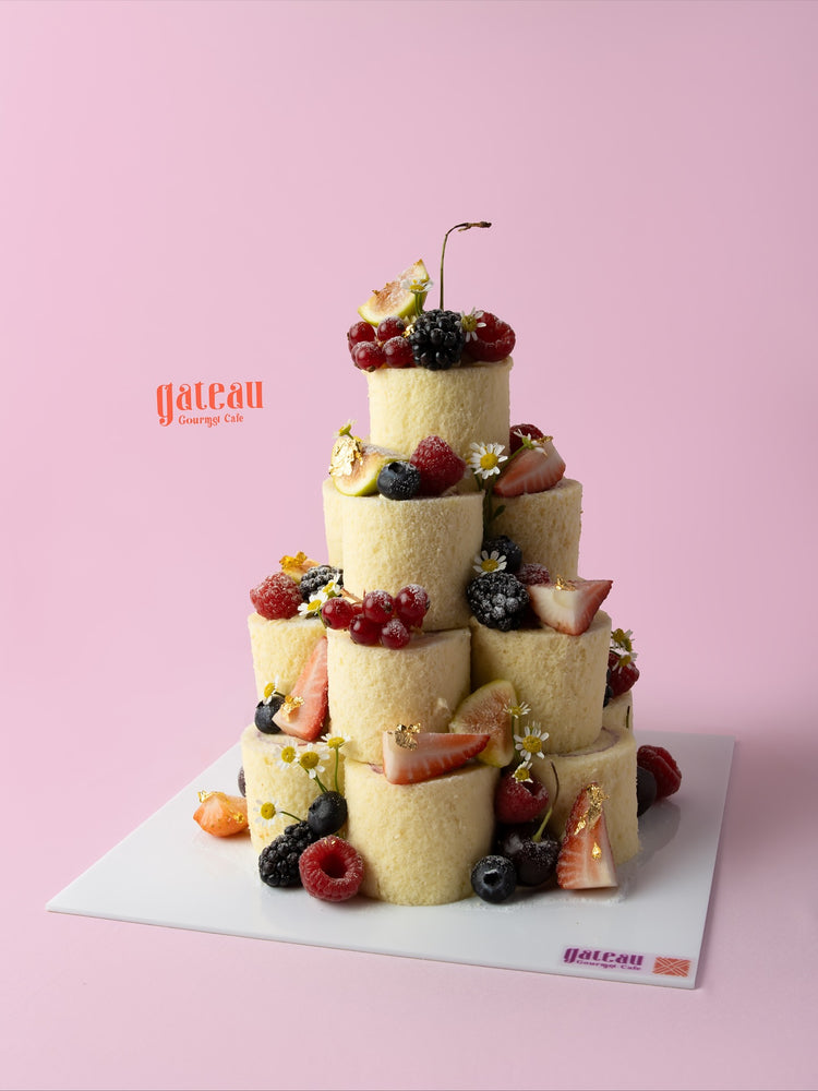 Vanilla fruit tower cake from Gateau Gourmet Cafe featuring layers of fresh fruits and flowers