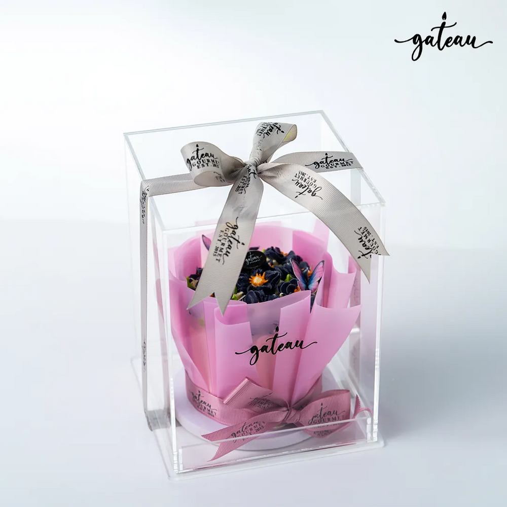 Violet Flowers in Bloom Cake Bouquet presented in a clear box with a decorative ribbon from Gateau Gourmet Cafe