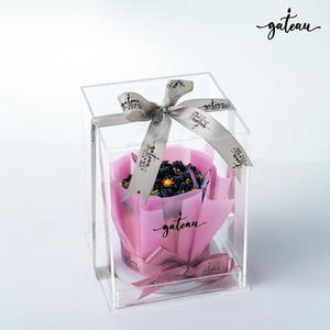 Violet Flowers in Bloom Cake Bouquet presented in a clear box with a decorative ribbon from Gateau Gourmet Cafe