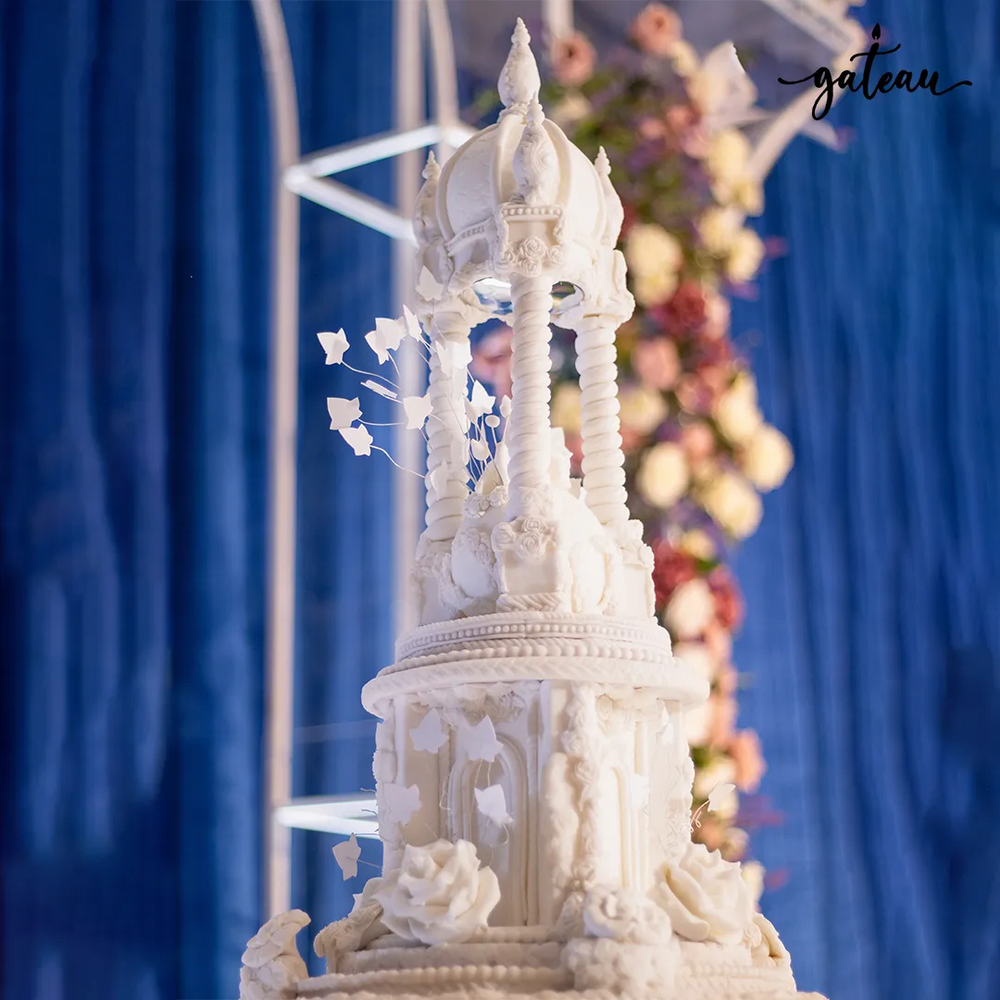 Detailed white gazebo wedding cake by Gateau Gourmet Cafe with intricate floral and architectural design