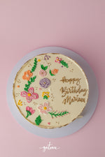 Gold tone garden Birthday Cake decorated with colorful flowers and a personalized message for a special celebration