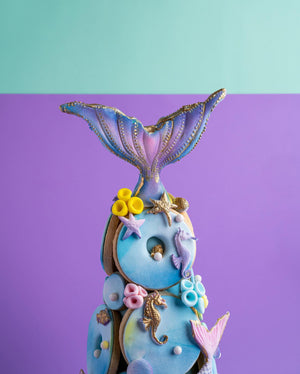 Decorative gourmet cookies delivery shaped like a colorful mermaid tail with sea-themed embellishments