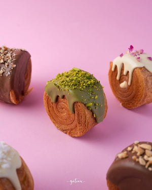 Gateau Gourmet Cafe gourmet croissant rolls with various chocolate and nut toppings on pink background