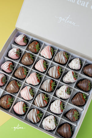 Box of gourmet dipped strawberries in various chocolate and drizzle designs from Gateau Gourmet Cafe