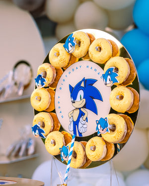 Sonic the Hedgehog themed cake with yellow gourmet donuts online arranged around a custom birthday center