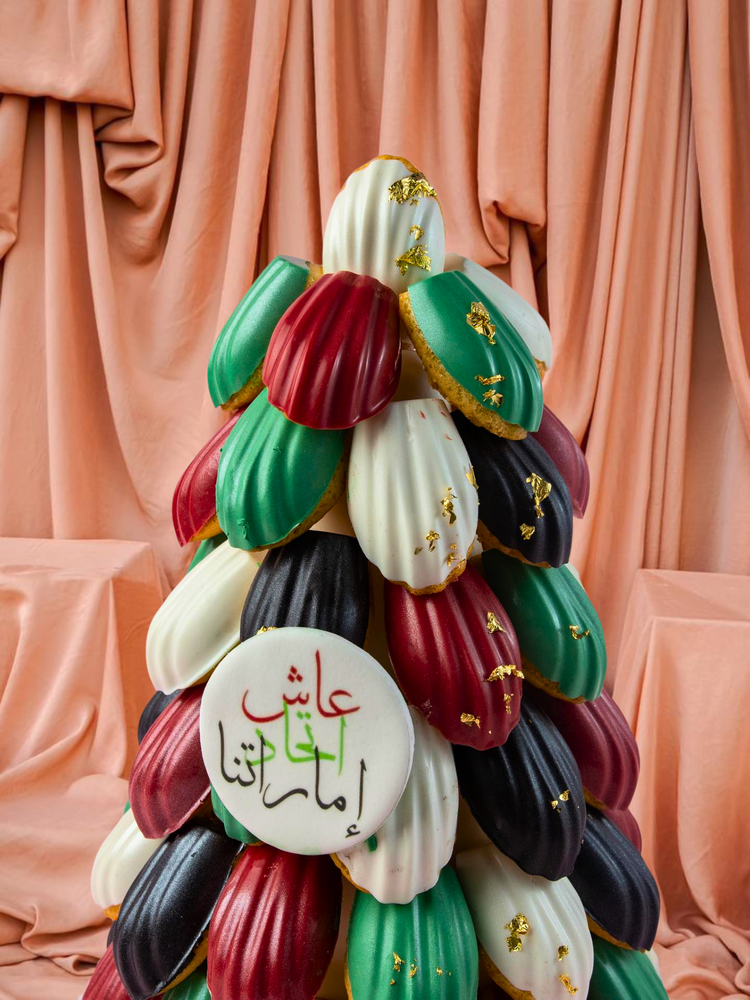 Colorful gourmet madeline dessert tower with golden accents at Gateau Gourmet Cafe