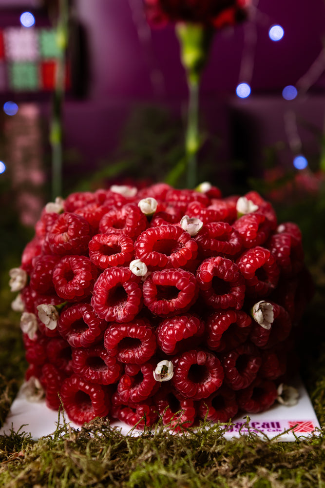 Gourmet raspberry cake arrangement topped with fresh raspberries and delicate accents for a festive celebration