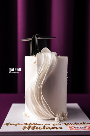 Elegant graduation celebration cake with a fondant wave design and a graduation cap decoration
