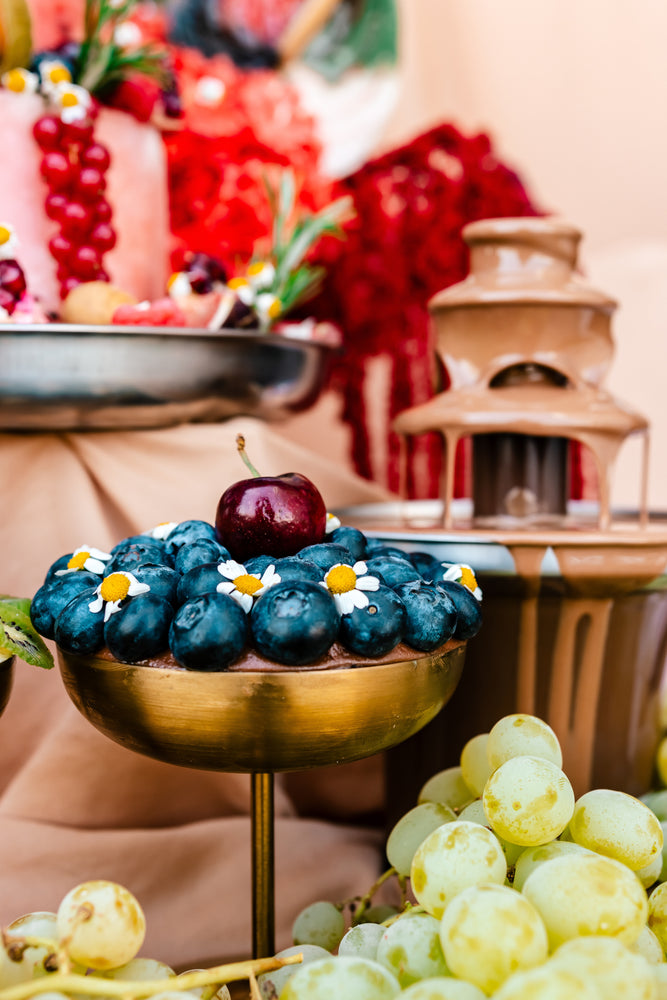 Guilt free fruit dessert featuring fresh blueberries and cherries on a decorative stand at Gateau Gourmet Cafe