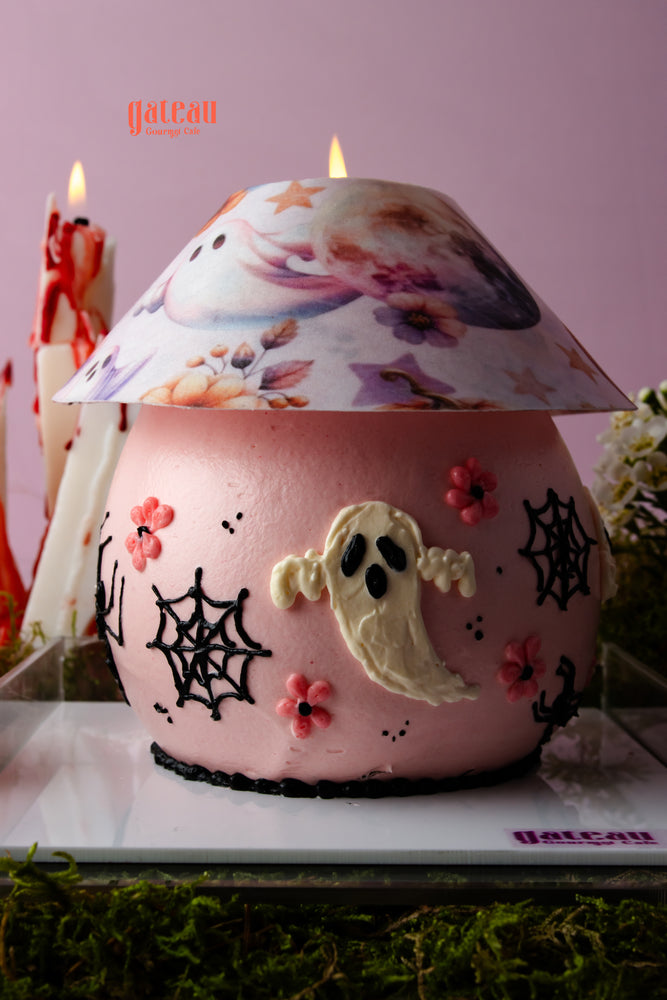 Halloween celebration cake with decorations featuring a ghost and spider webs designed for festive occasions