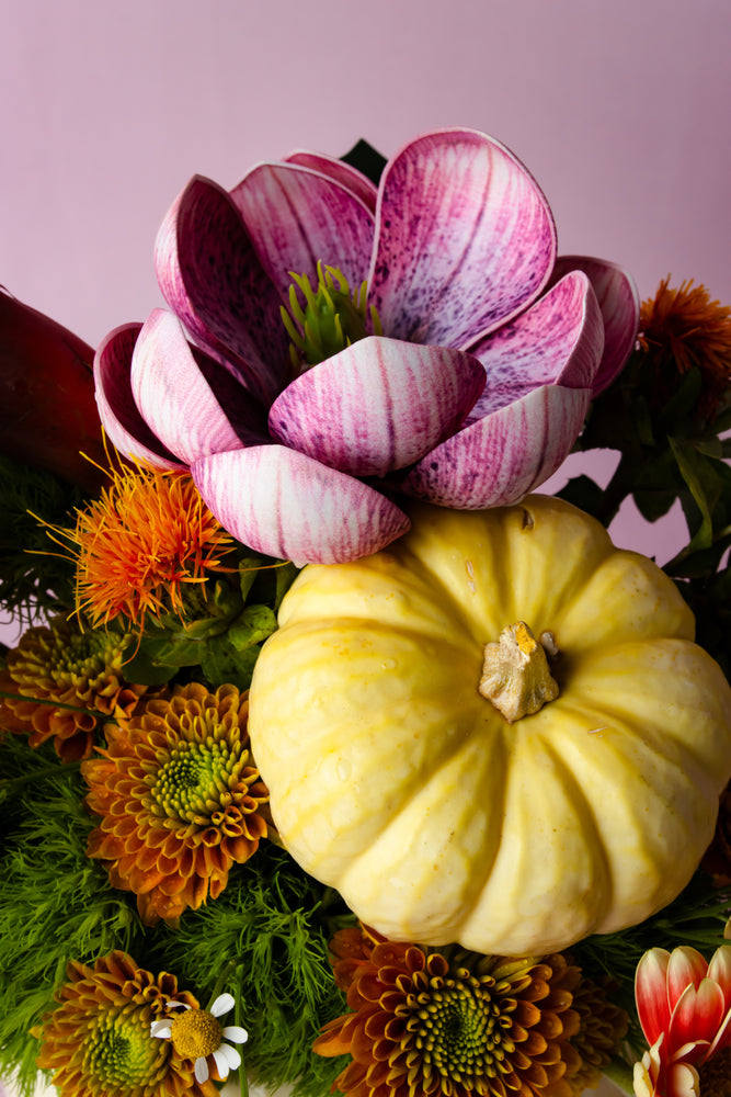 Halloween pumpkin vase with flowers featuring colorful blooms and decorative elements