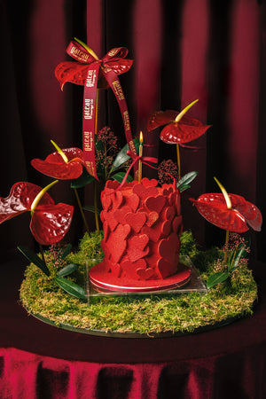 Heart Bundle Cake With Arrangement featuring a red cake adorned with heart shapes and decorative flowers