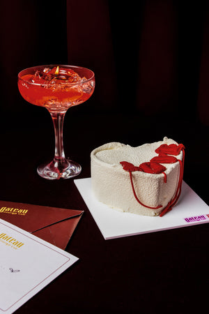 Heart Love Mini Cake With Candle decorated with rose petals, paired with a red cocktail and elegant envelopes