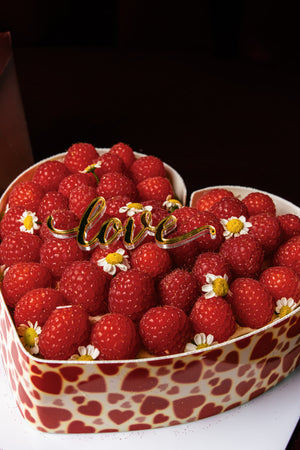 Heart shape raspberry tart from Gateau Gourmet Cafe topped with fresh raspberries and decorative flowers