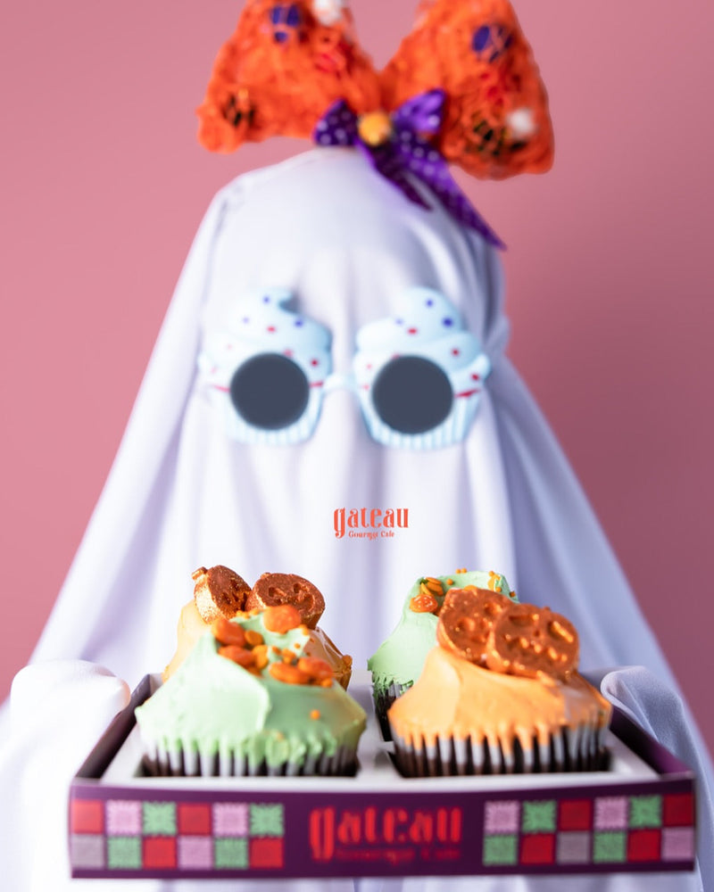 Hello pumpkin cupcake with colorful icing and pretzel topping from Gateau Gourmet Cafe