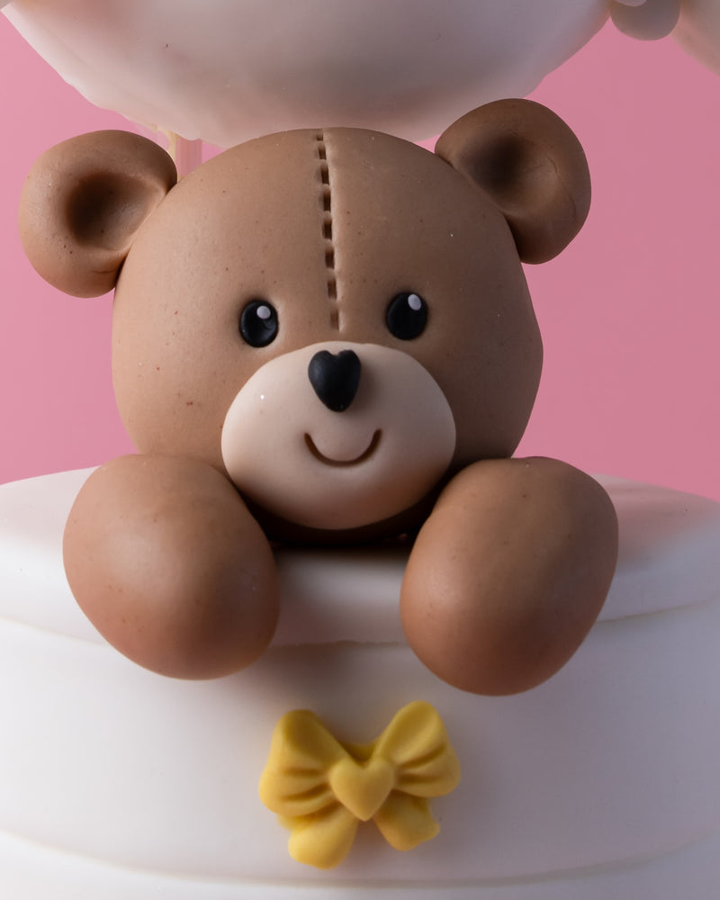Close-up of a cute hello-teddy-bear-cake featuring a smiling fondant teddy bear decoration