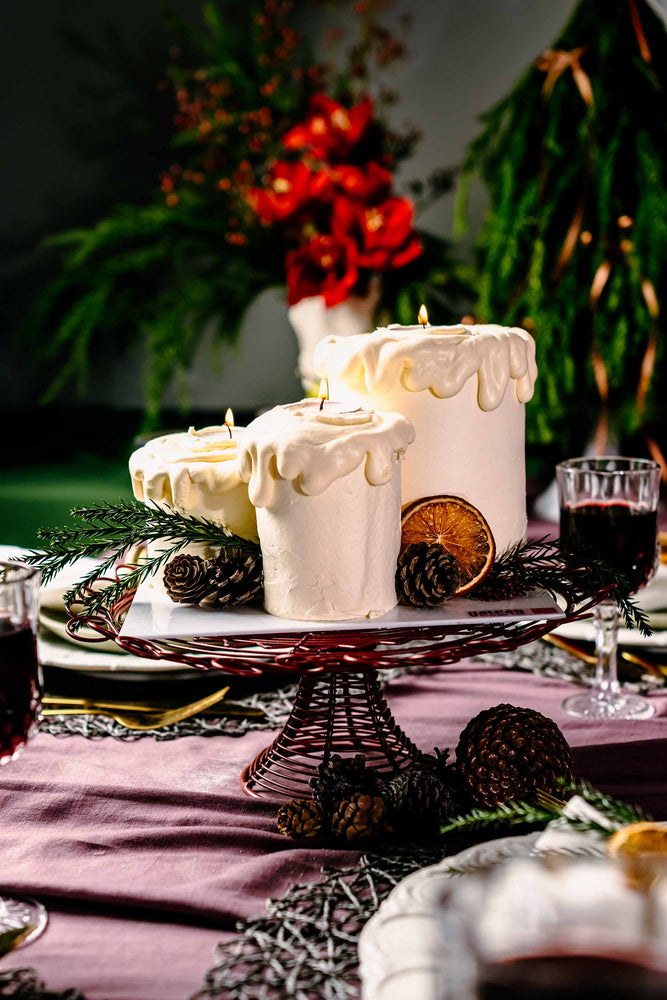 Holiday cakes for Christmas by Gateau Gourmet Cafe with white icing candles and festive pinecone decor