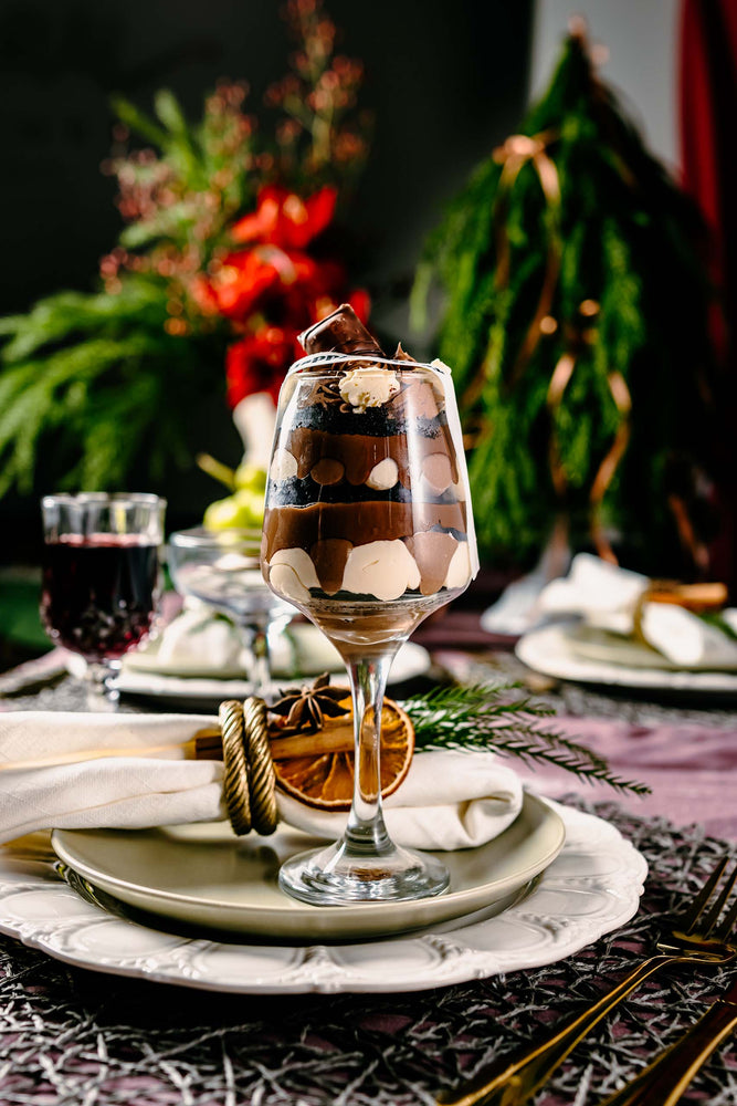 Layered chocolate and cream cake dessert in a glass on festive table, perfect holiday desserts for parties