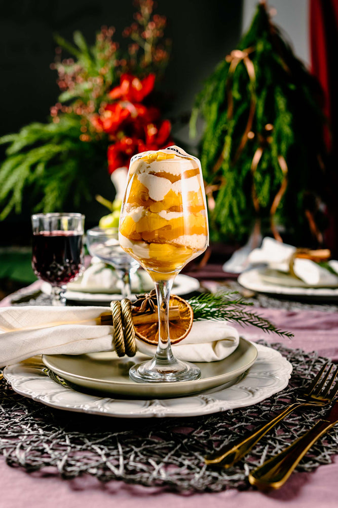 Holiday desserts for parties featuring layered cake dessert in a wine glass on elegant holiday table setting